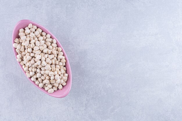 Bol de pois chiches, prêt pour la cuisson, sur une surface en marbre