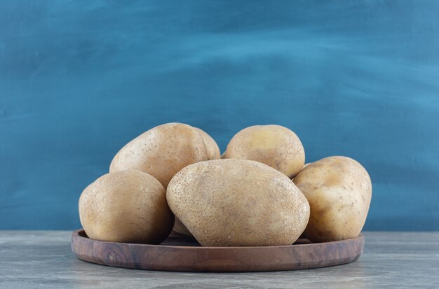 Un bol de pommes de terre mûres sur la table en marbre.