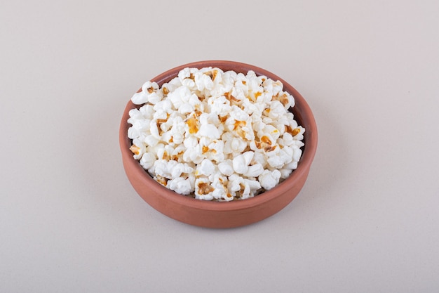 Bol de pop-corn salé pour une soirée cinéma sur fond blanc. photo de haute qualité