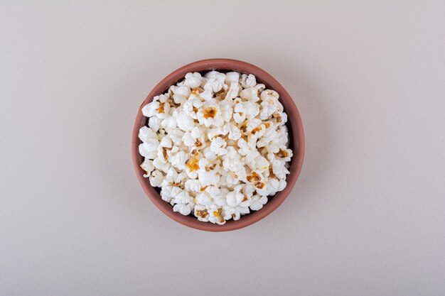 Bol de pop-corn salé pour une soirée cinéma sur fond blanc. photo de haute qualité