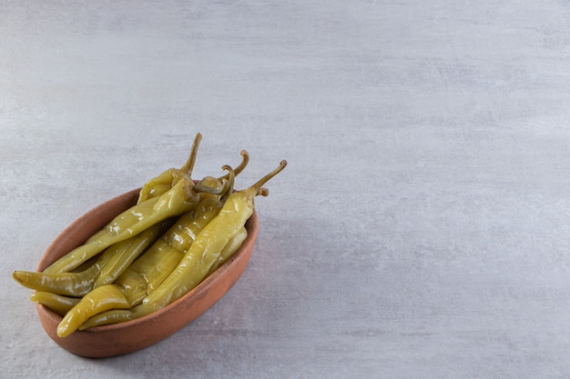 Bol profond de piments fermentés sur table en pierre.