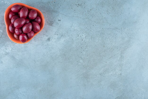 Un bol de prunes fermentées sur la surface en marbre