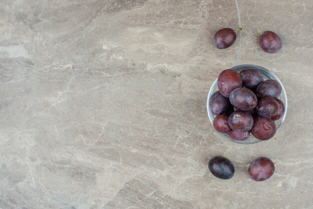 Bol de prunes fraîches sur marbre.