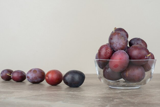 Bol de prunes fraîches sur table en marbre.