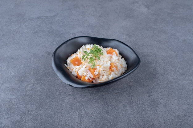 Photo gratuite un bol de riz aux carottes , sur la surface en marbre.