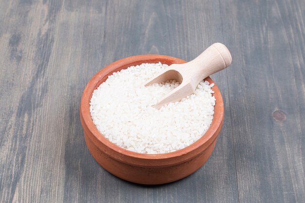 Bol de riz bouilli avec cuillère sur table en bois