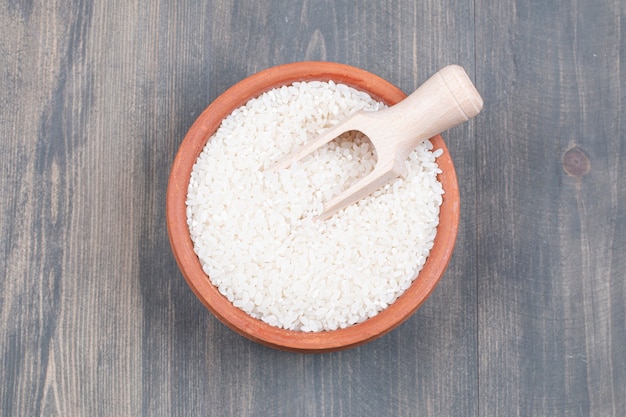 Bol de riz bouilli avec cuillère sur table en bois