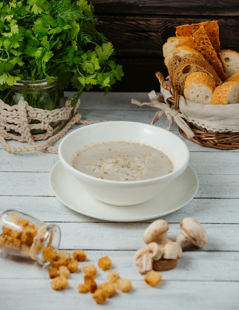 un bol de soupe aux champignons servi avec farce au pain, coriandre sur le pot