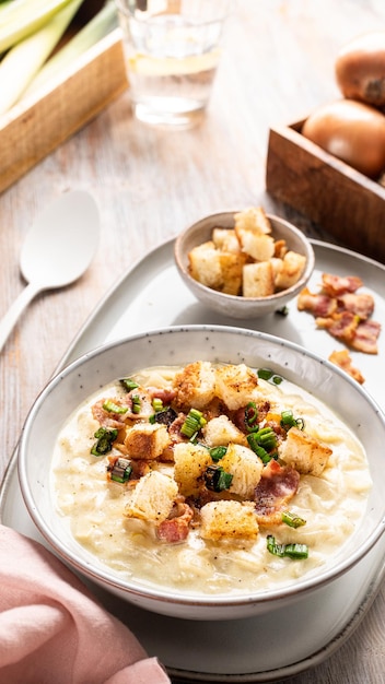 Photo gratuite bol de soupe chaude au fromage de poireaux avec croûtons et bacon sur une table en bois soupe de poireaux au fromage