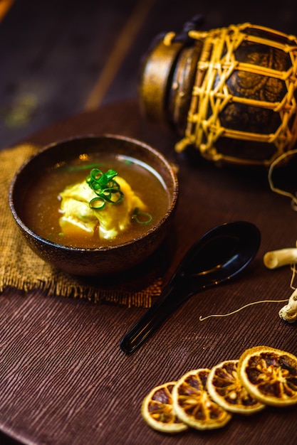 Photo gratuite un bol de soupe chinoise garnie d'oignons verts coupés en dés