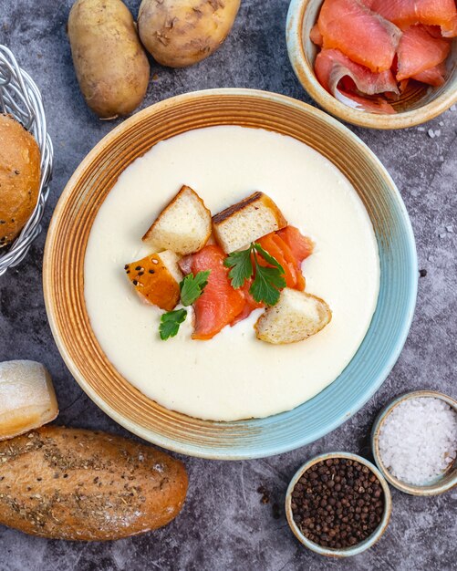 Bol de soupe crémeux garni de farce de pain de saumon et de persil