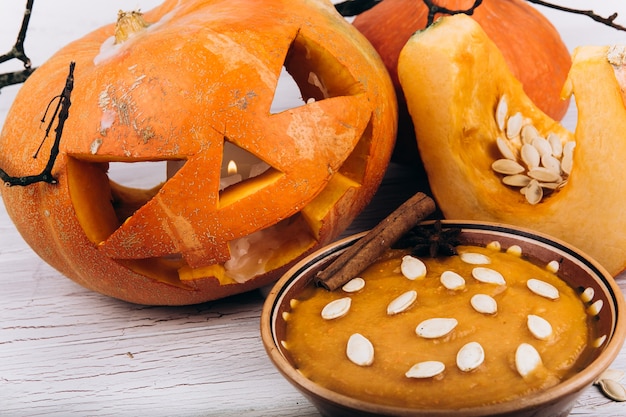 Bol avec soupe se dresse avant la scarry Halloween citrouille sur la table