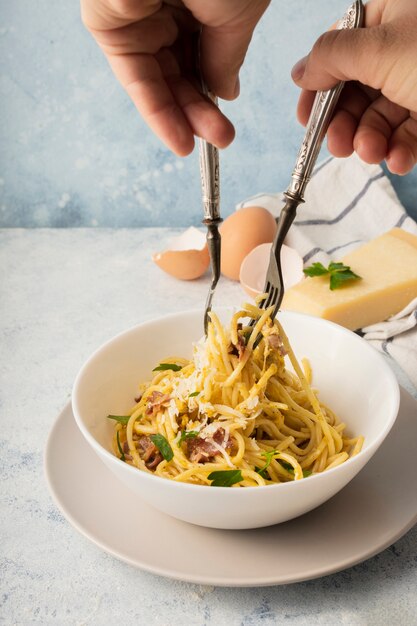 Bol à spaghetti à angle élevé avec oeufs en parmesan et fourchettes