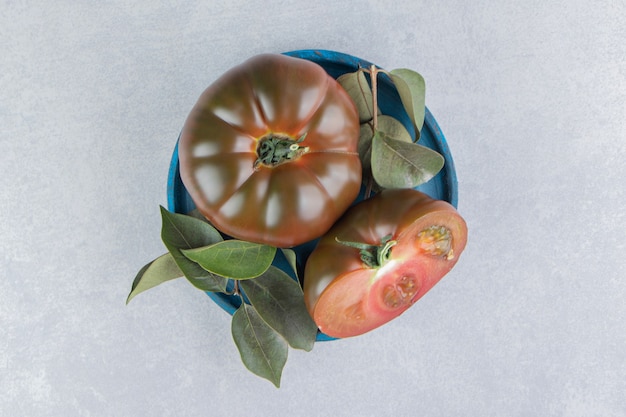 Un bol de tomates mûres sur la surface en marbre