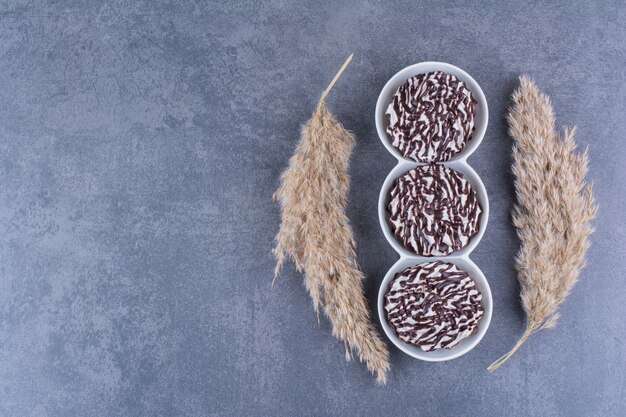 Bols blancs de biscuits au sirop de chocolat sur une pierre.