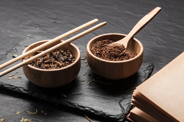 Bols en bois avec insectes sur ardoise