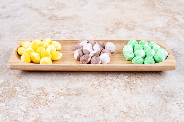 Bonbons assortis regroupés dans un petit plateau en bois