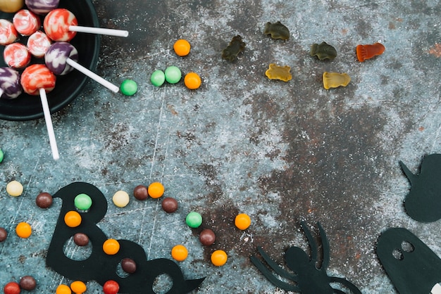 Bonbons et attributs décoratifs d&#39;Halloween sur les bords