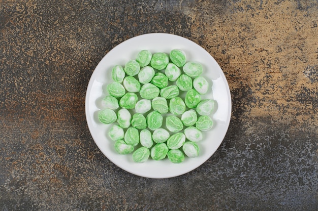 Bonbons au menthol vert sur plaque blanche.