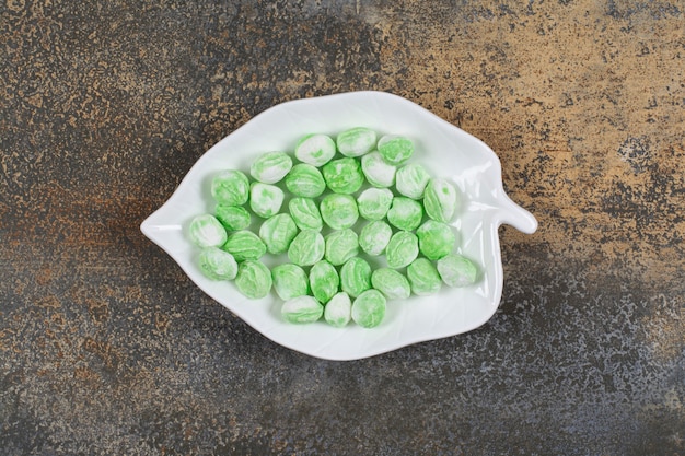 Bonbons au menthol vert sur plaque en forme de feuille.