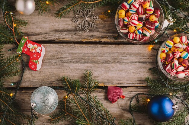 Bonbons, boules de Noël et branches d'épinette sur une surface en bois