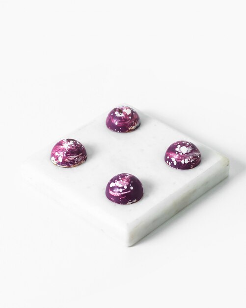 Bonbons choco conçus pourpre délicieux délicieux sur la surface blanche