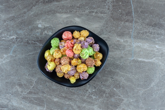 Bonbons colorés faits maison frais dans un bol noir.