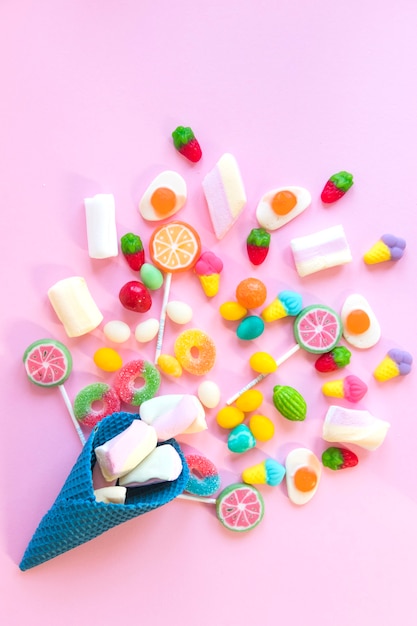 Bonbons éparpillés sur une table rose