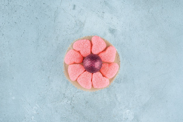 Photo gratuite bonbons en forme de coeur en sucre avec boule de noël brillante.