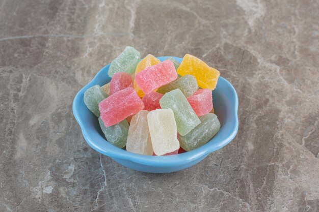 Bonbons à la gelée arc-en-ciel dans un bol bleu. Bonbons à la gelée colorés.