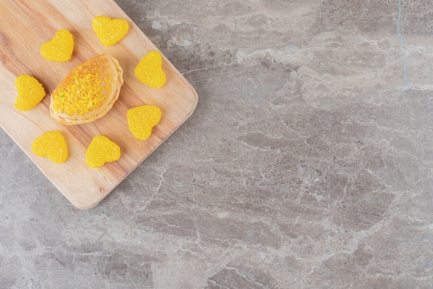 bonbons à la gelée autour d'un petit pain avec garniture en poudre aromatisée au citron sur une surface en marbre