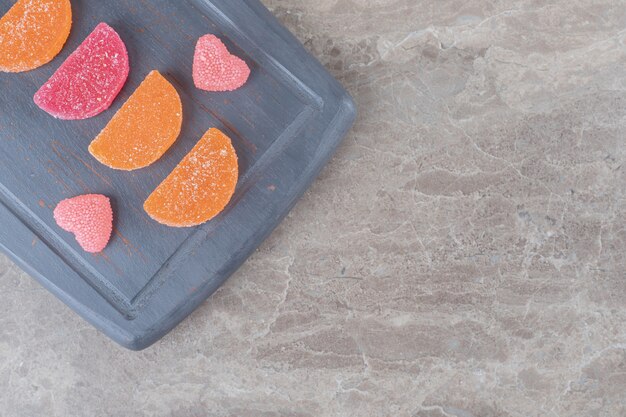 bonbons à la gelée soigneusement disposés sur un tableau marine sur une surface en marbre