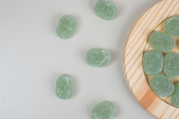 Bonbons de gelée sucrée verte sur des assiettes en bois