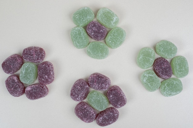 Bonbons à la gelée vert et violet sur une surface beige