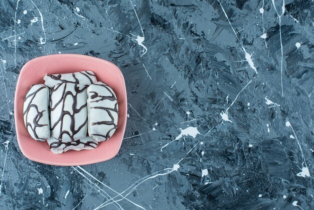 Bonbons glacés dans un bol, sur la table bleue.