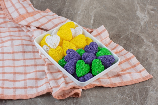 Bonbons jaunes violets et verts. Délicieux bonbons sur plaque blanche.