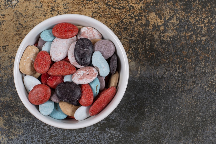 Photo gratuit bonbons en pierre de forme ovale dans un bol blanc.