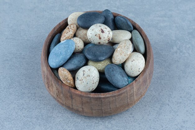 Bonbons en pierre de galets dans un bol, sur la table en marbre.