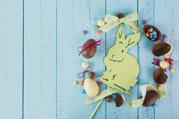 Bonbons et rubans de Pâques autour du lapin