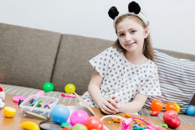 Bonheur fille enfant sourire avec jouet ball coloré sur canapé