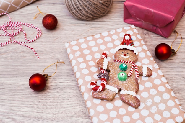 Photo gratuite bonhomme de neige en biscuit sur un cadeau près de boules de noël