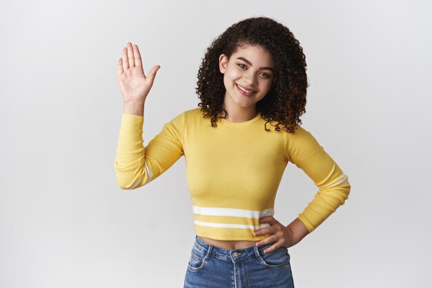 Bonjour donner cinq bon travail Charmante amicale souriante jeune fille féminine lever la main paume salut geste de salutation tête inclinable rencontrer des gens accueillant des collègues se présenter nouvelle équipe