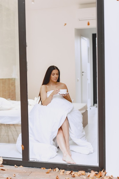 Bonjour. Femme boit du café. Dame à la fenêtre.