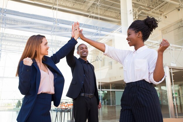 Bonne équipe forte entreprise fait haut cinq au bureau