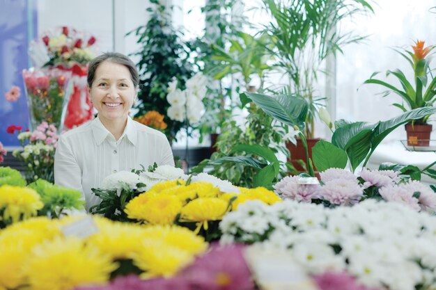 Bonne femme mature dans le magasin de fleurs