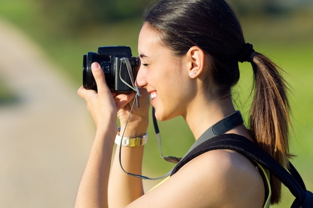 Bonne fille qui prend des photos dans le champ