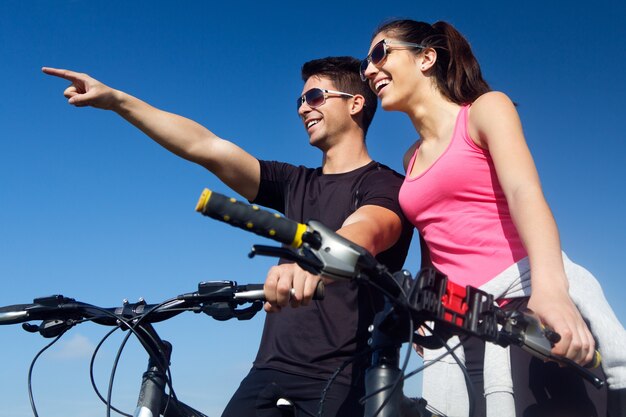 Bonne jeune couple en vélo à la campagne