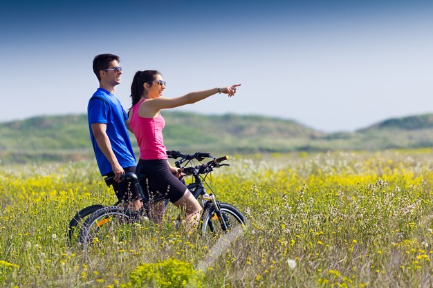 Bonne jeune couple en vélo à la campagne