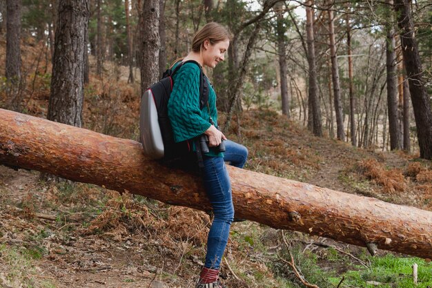 Bonne jeune femme assise sur un journal