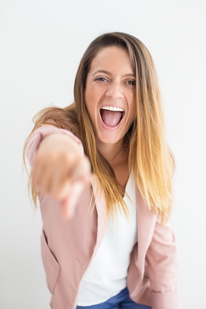 Bonne jeune femme criant et montrant une caméra